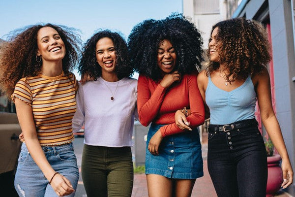 Four women laughing and smiling