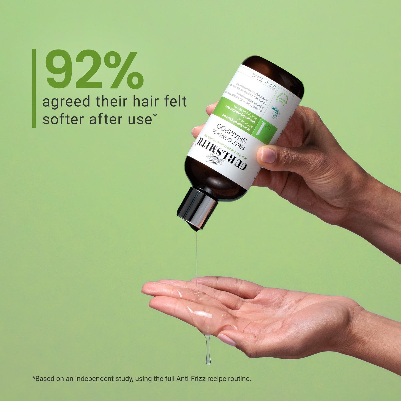 Hand holding a bottle of hair product with text on a green background