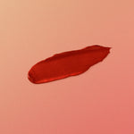 Red lipstick swatch on a pink background